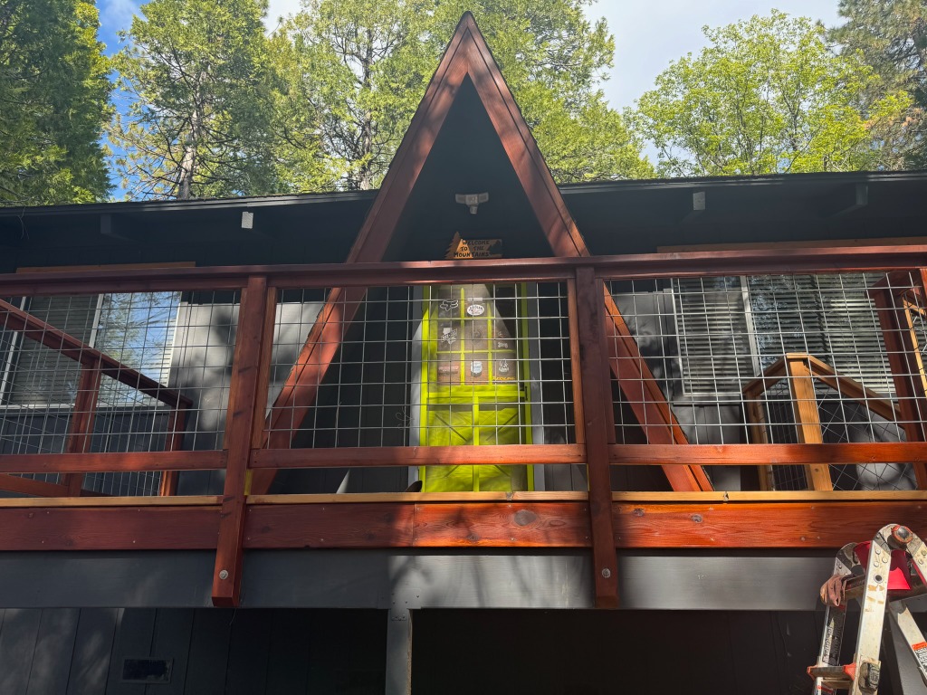 Front view of a cabin deck with wood-framed hog panel railing